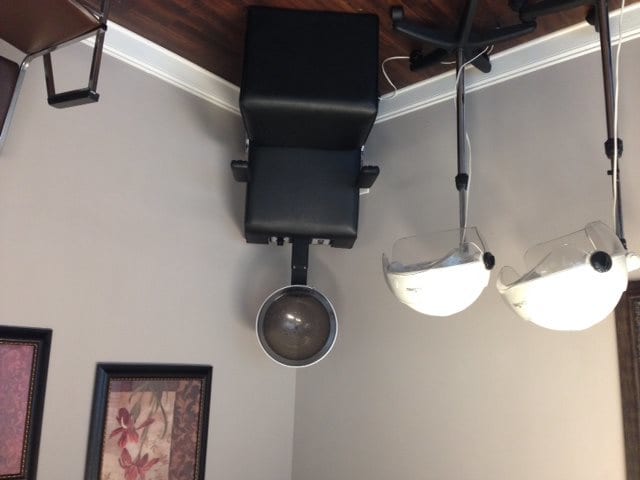 An upside-down hair salon interior with a ceiling-mounted hair dryer and lights.