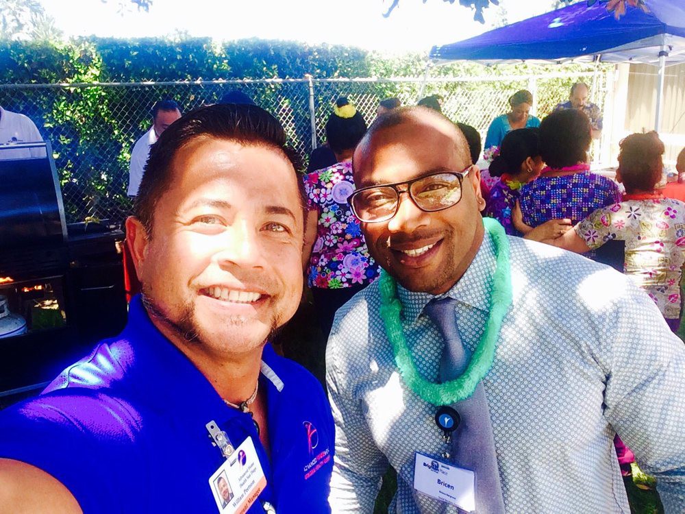 Two people smiling at an outdoor event.
