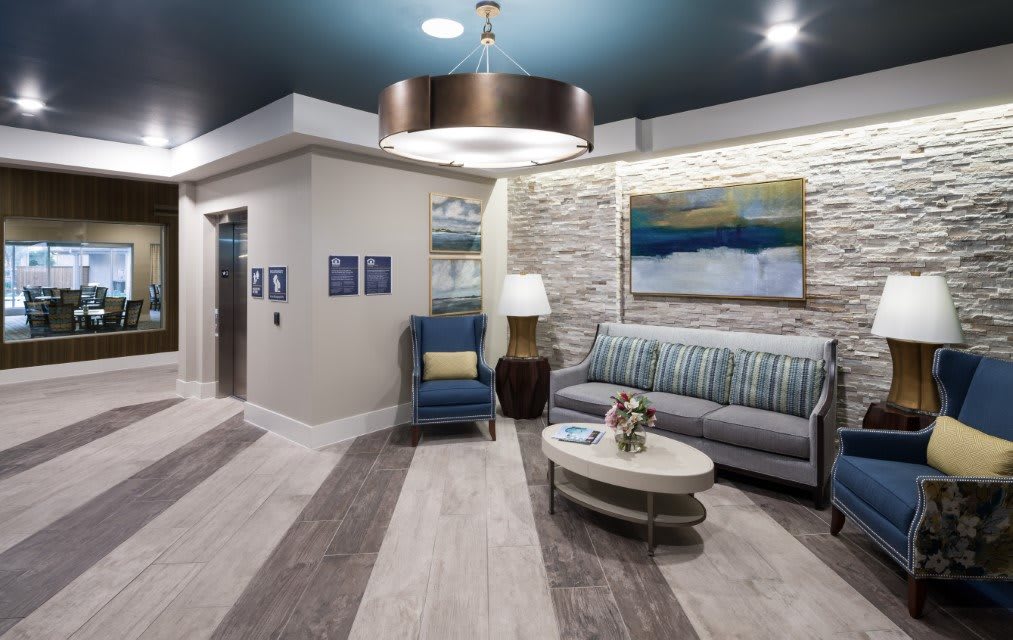 A modern lobby featuring a cozy seating area with stylish furniture and wall art.