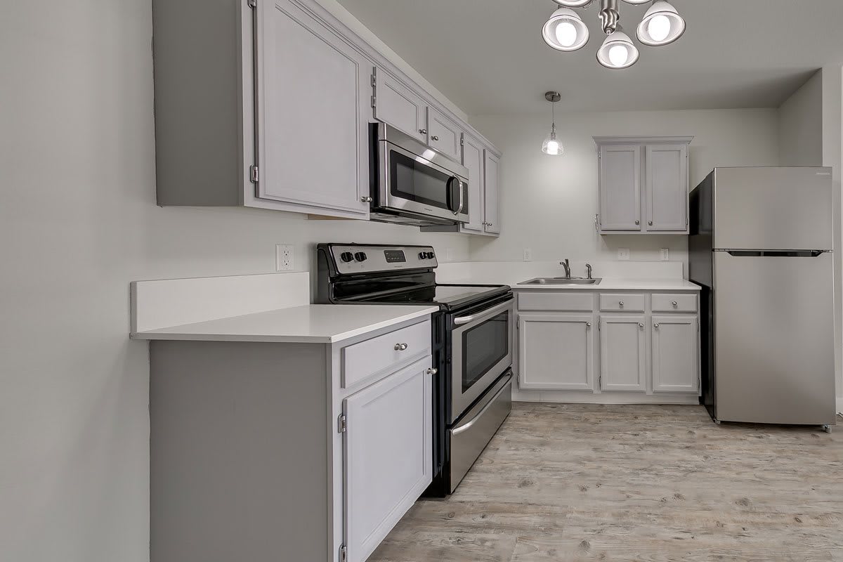 A modern kitchen with white cabinets and stainless steel appliances.