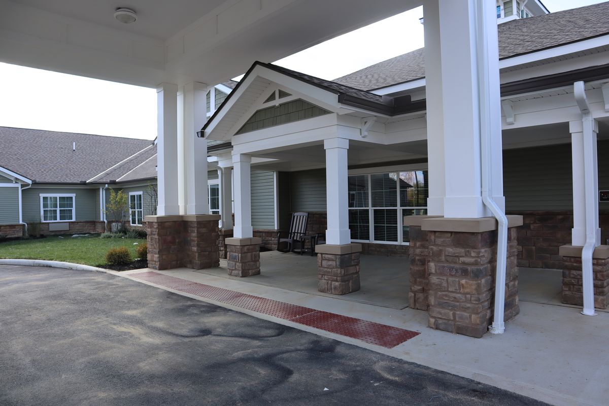 An entrance with columns and a covered porch leading to a building.