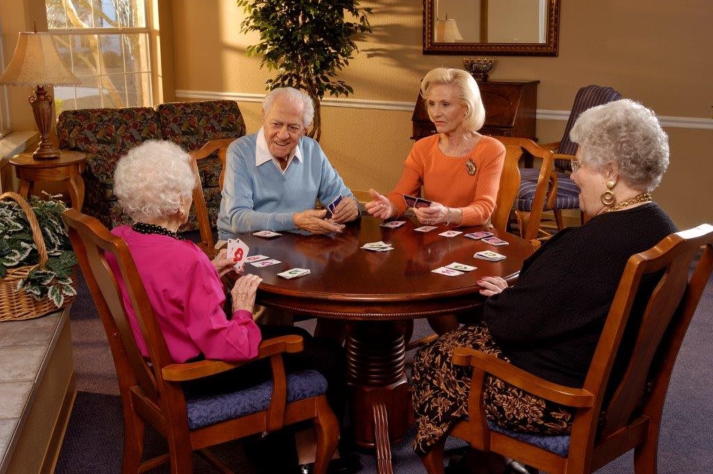 A group of elderly women playing cards together at a table.