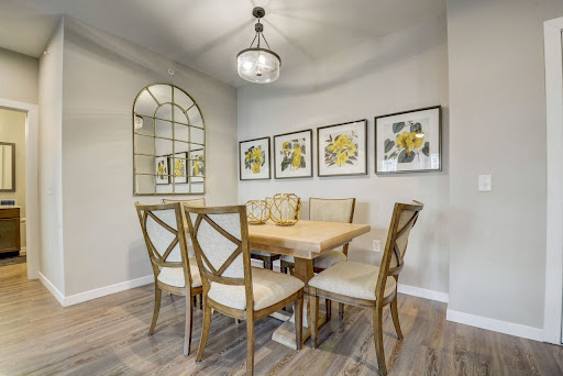 A cozy dining room featuring a wooden table, stylish chairs, and decorative artwork on the walls.