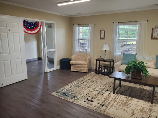 A cozy living room featuring a comfortable chair, coffee table, and decorative elements.
