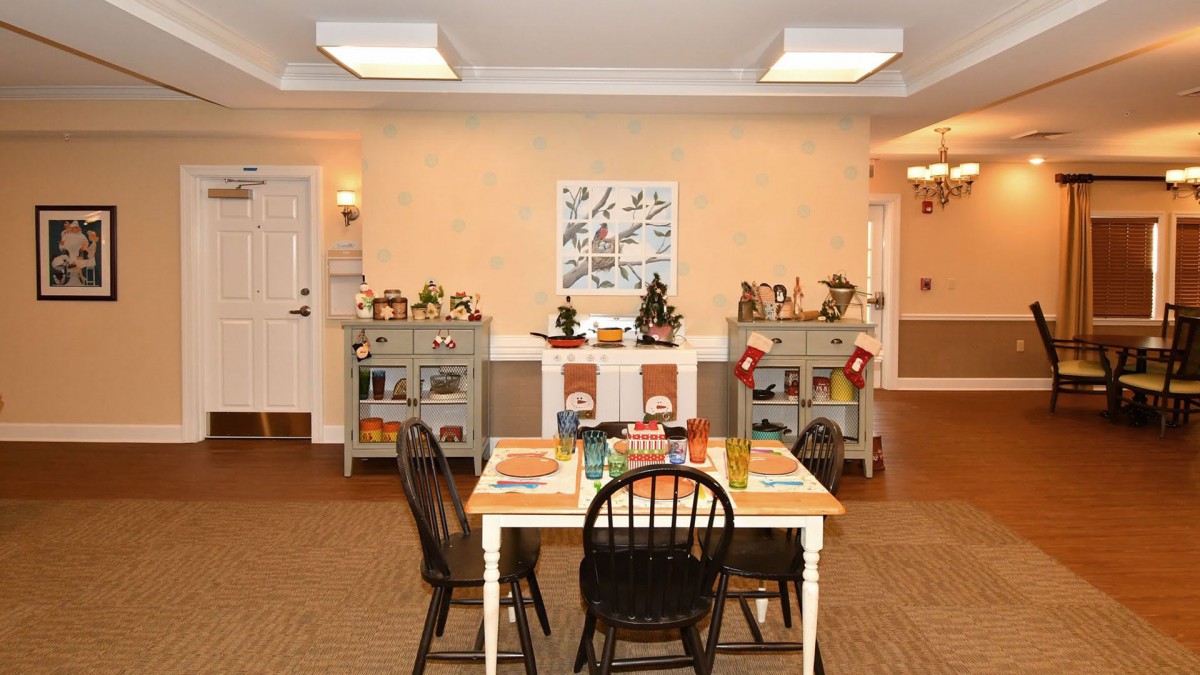A cozy dining area with a table and chairs, featuring warm decorations and wall art.