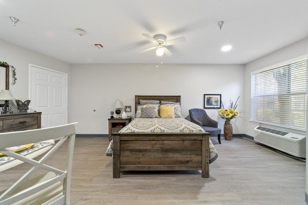 A modern bedroom featuring a wooden bed, comfortable chair, and stylish decor.