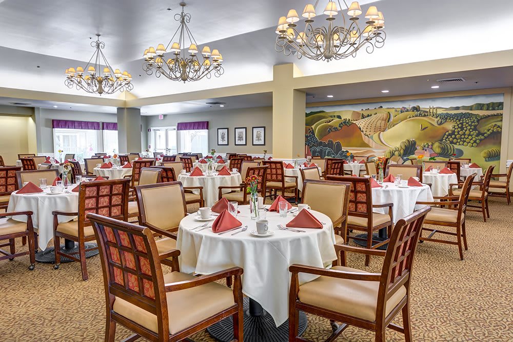 Elegant dining room with neatly arranged tables and stylish chandeliers.