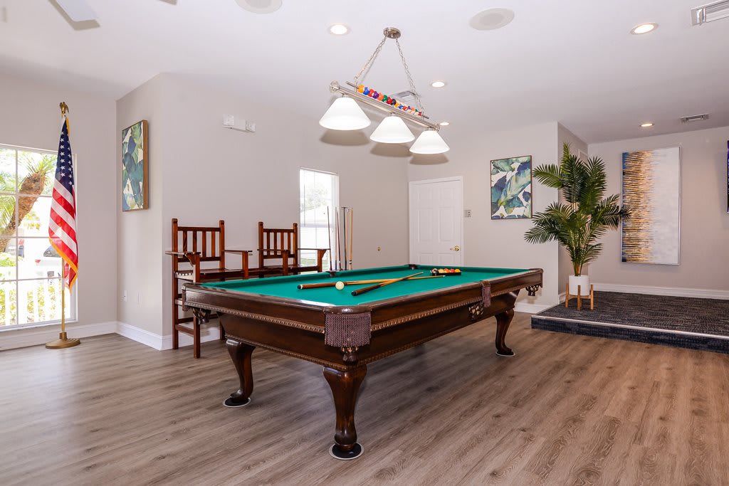 A stylish game room featuring a classic pool table and elegant decor.