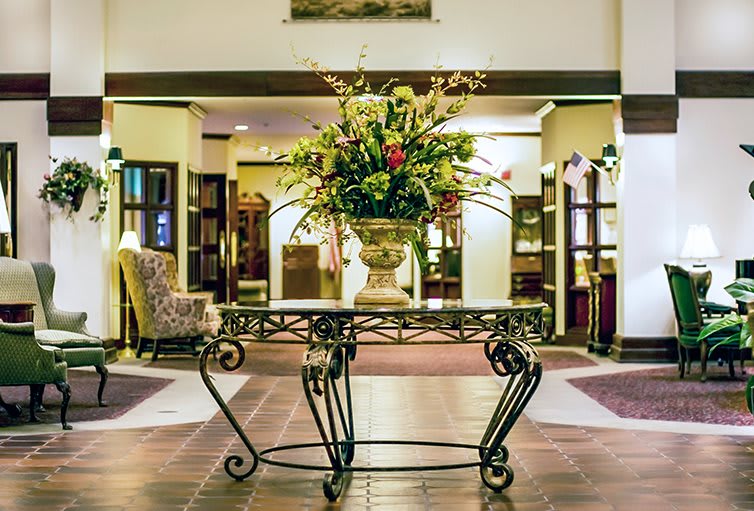 Elegant hotel lobby with a floral arrangement centerpiece.