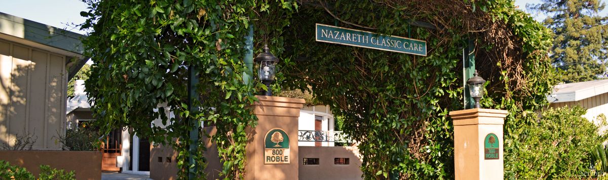 An outdoor scene showing a street sign labeled 'Nazareth Classic' next to a lamp and building entrance marked 'Old Roble'.