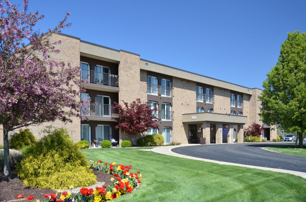 A hotel building with landscaped gardens and colorful spring flowers.
