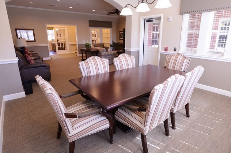 A well-furnished dining area with a wooden table and striped chairs.