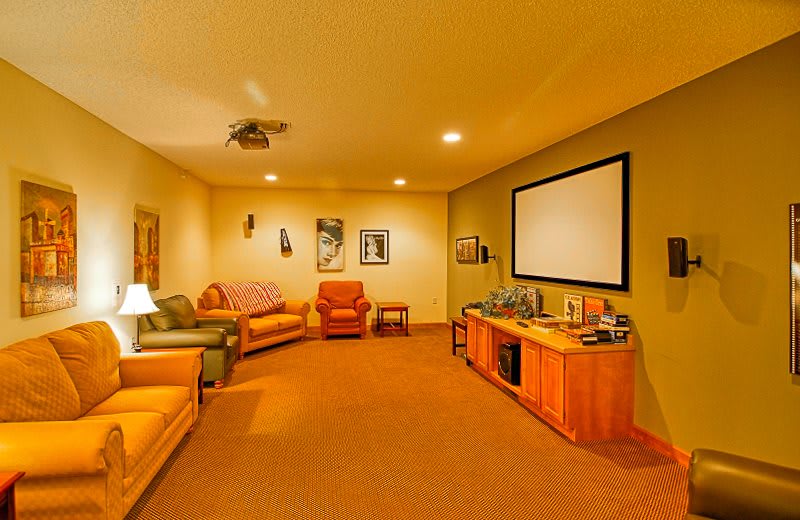 A cozy home theater room with comfortable seating and a projector screen for entertainment.