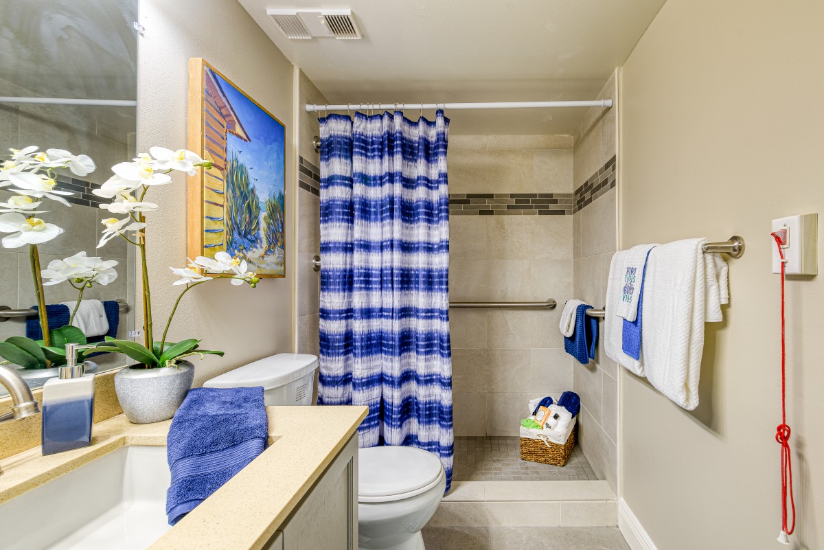 A neat and colorful bathroom with a blue and white shower curtain.