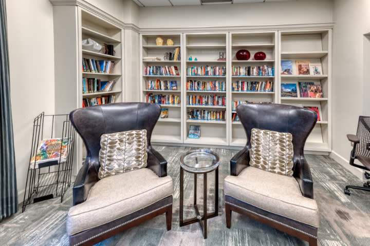Cozy reading area with armchairs and bookshelves in a library.