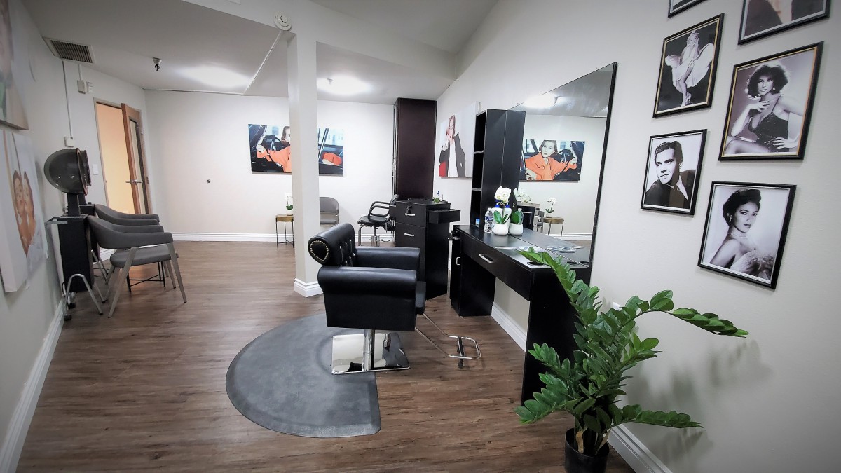 A modern hair salon interior with stylish chairs and mirrors.