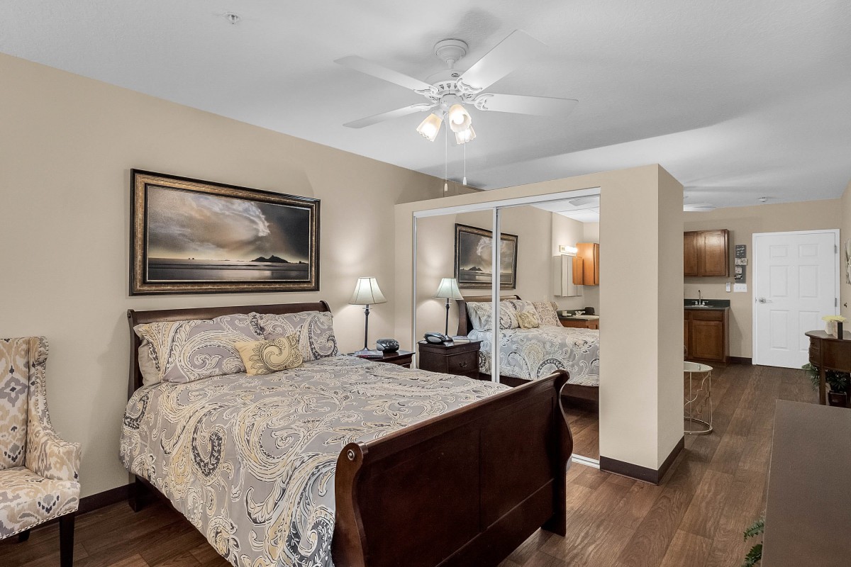 A cozy bedroom with a wooden sleigh bed and mirrored closet doors.