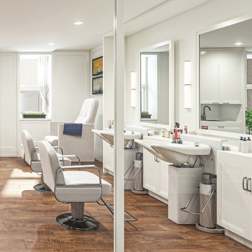A modern and clean interior of a salon featuring stylish barber chairs and well-lit mirrors.