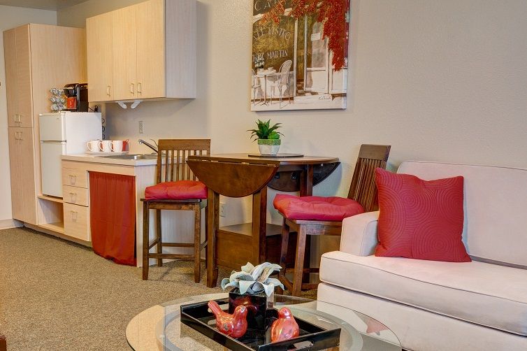 A cozy living room with a dining area, featuring red accents and modern decor.