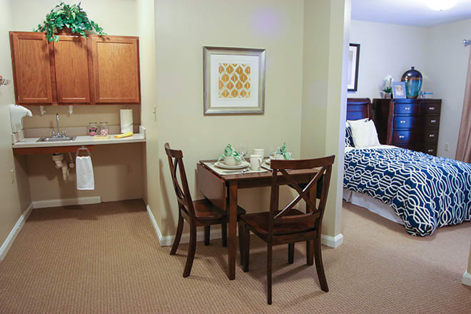 A cozy dining area with a small table and chairs adjacent to the kitchen and bedroom.