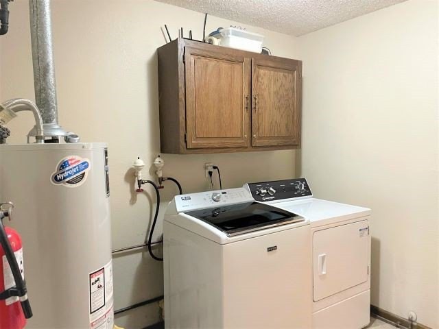 A functional laundry room equipped with a washer, dryer, and storage cabinet.