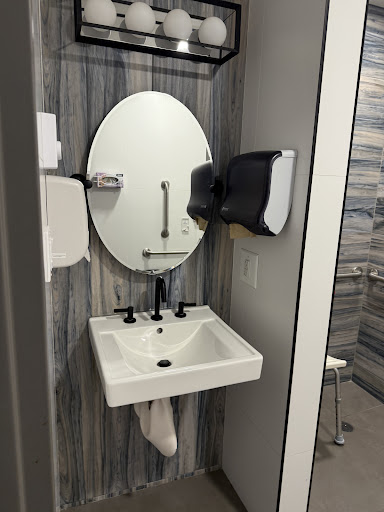 A modern restroom featuring a sleek sink, mirror, and hand dryer.