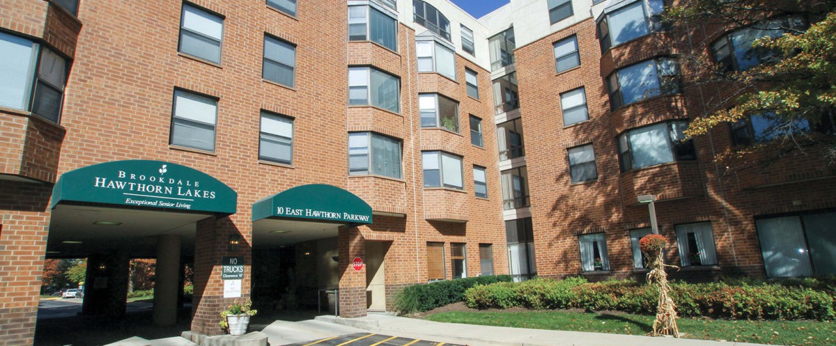 A multi-story brick apartment building with an entrance canopy.
