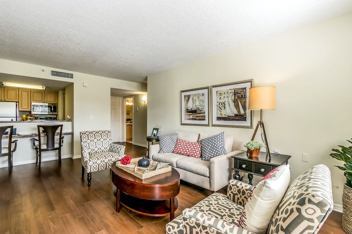 A cozy living room showcasing modern interior design with a sofa, patterned chairs, and decorative elements.