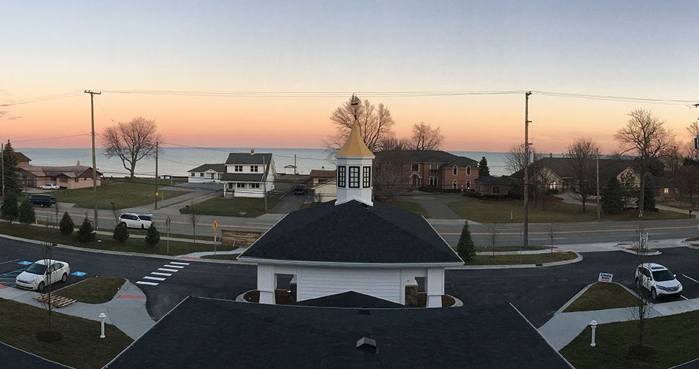 A peaceful sunset view over lakeside houses with a vibrant sky.