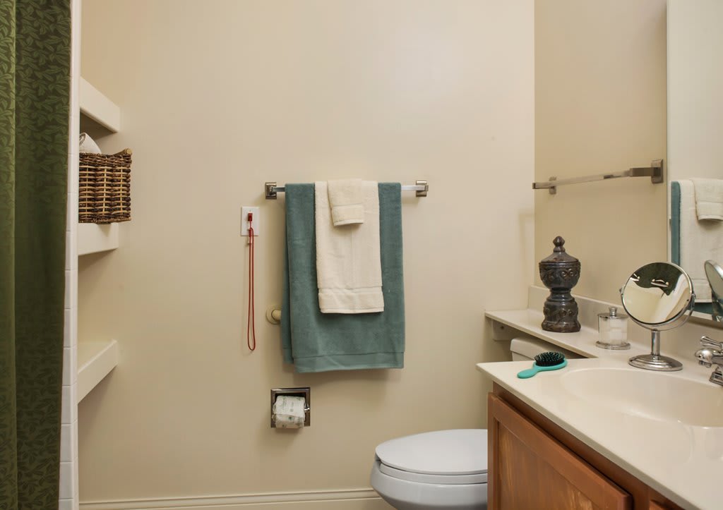 A tidy bathroom with neatly hung towels and a well-organized sink area.