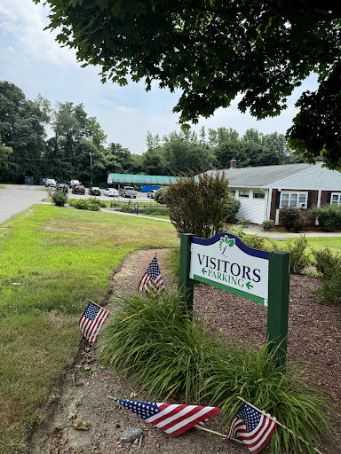 A welcoming visitors center surrounded by greenery and American flags.