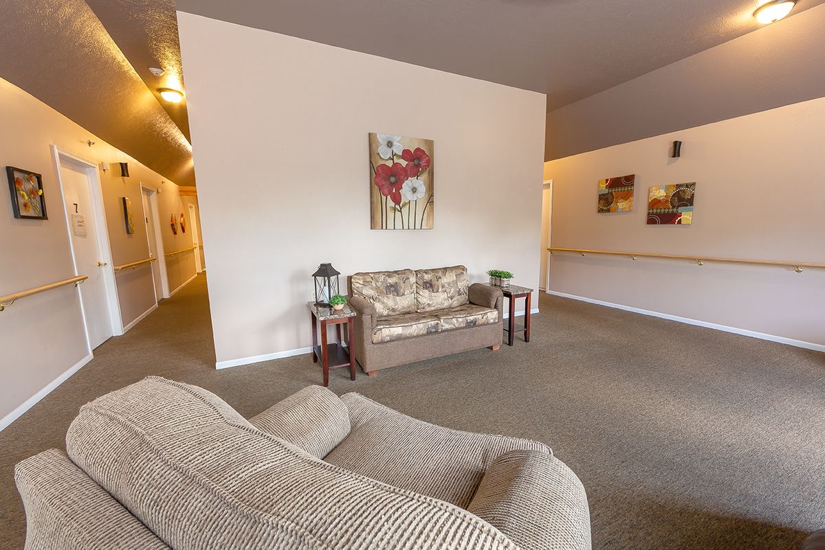 A cozy living room with a sofa, side tables, and a painting on the wall.