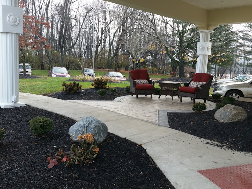 A cozy outdoor patio area with comfortable seating, surrounded by a well-maintained garden.