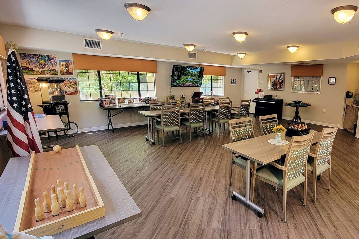 A comfortable dining area with tables, chairs, and a television.