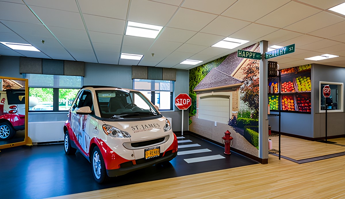 An indoor showroom featuring a smart car with a decorative mural and street signage.