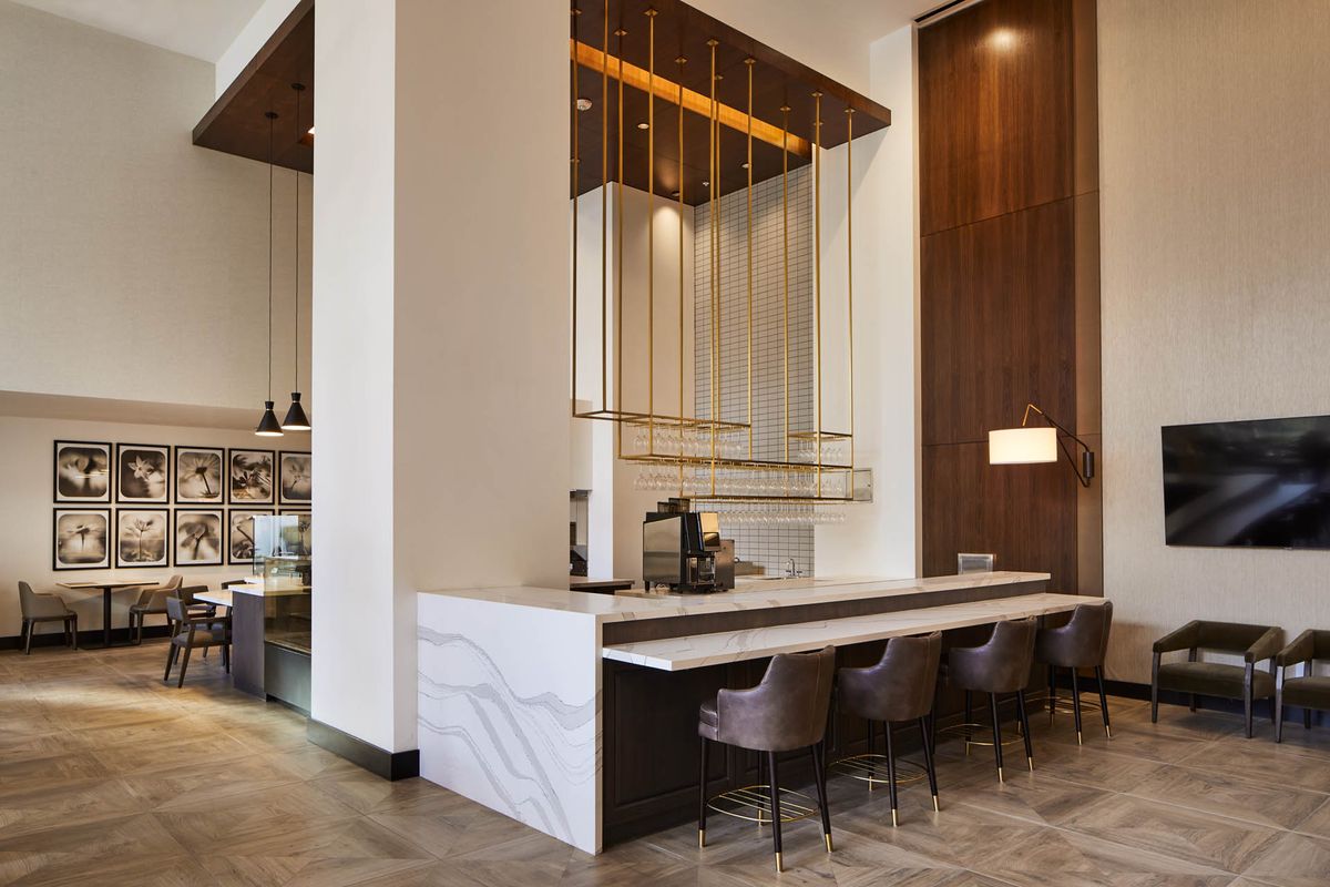 A modern cafe interior with bar seating and contemporary lighting.