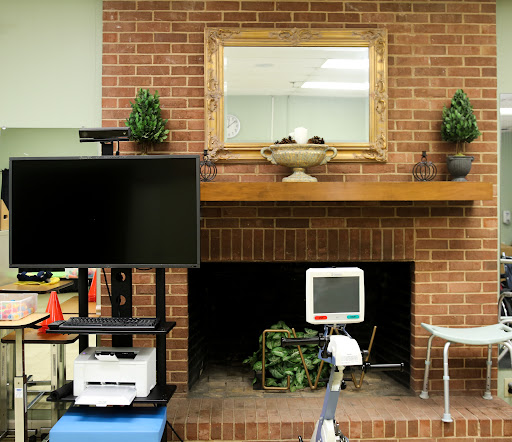 A cozy interior space featuring a television, a medical monitor, and decorative elements against a brick wall.