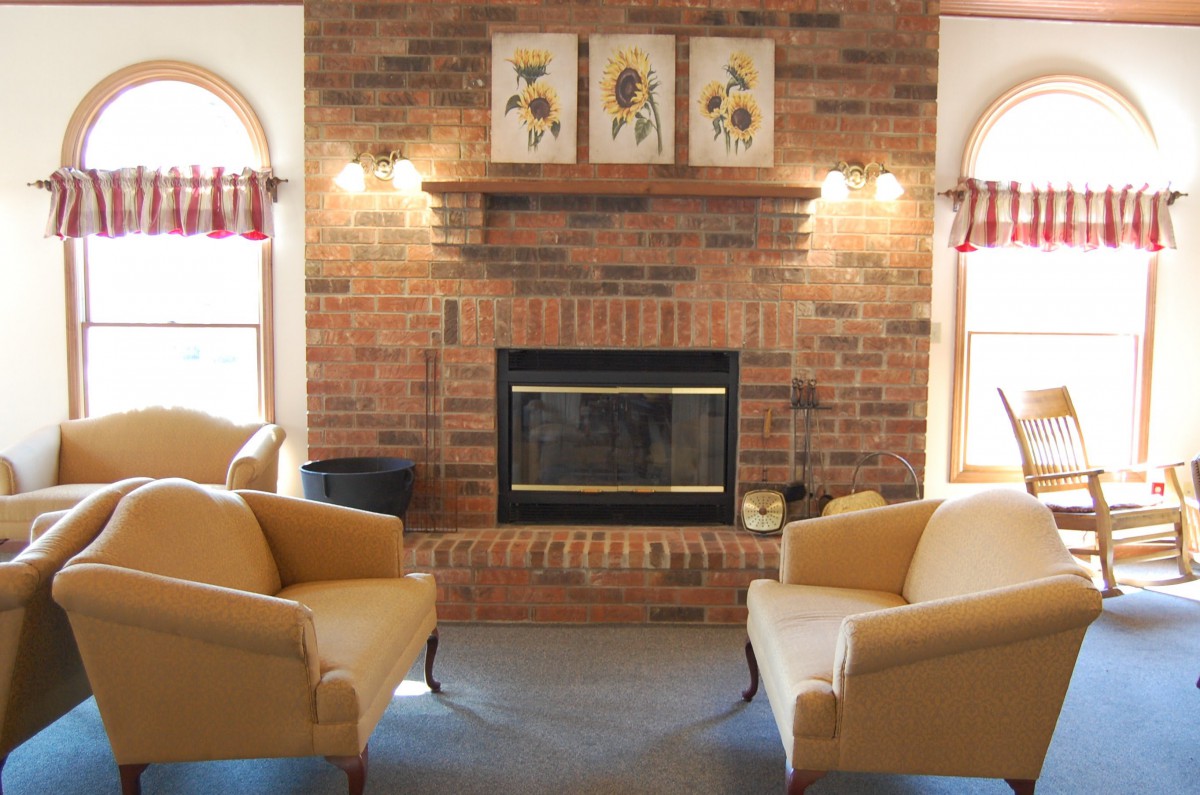 A cozy living room with a brick fireplace and comfortable armchairs.