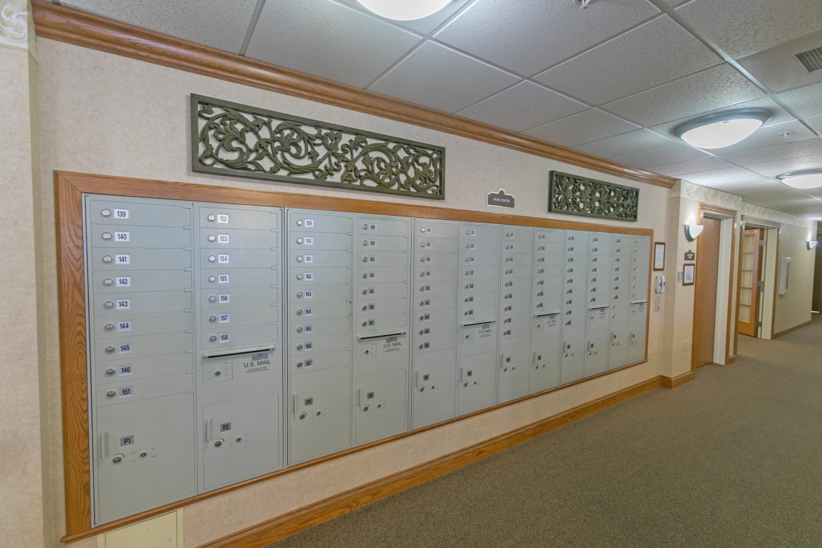 An indoor hallway featuring a row of metal mailboxes in an apartment building.
