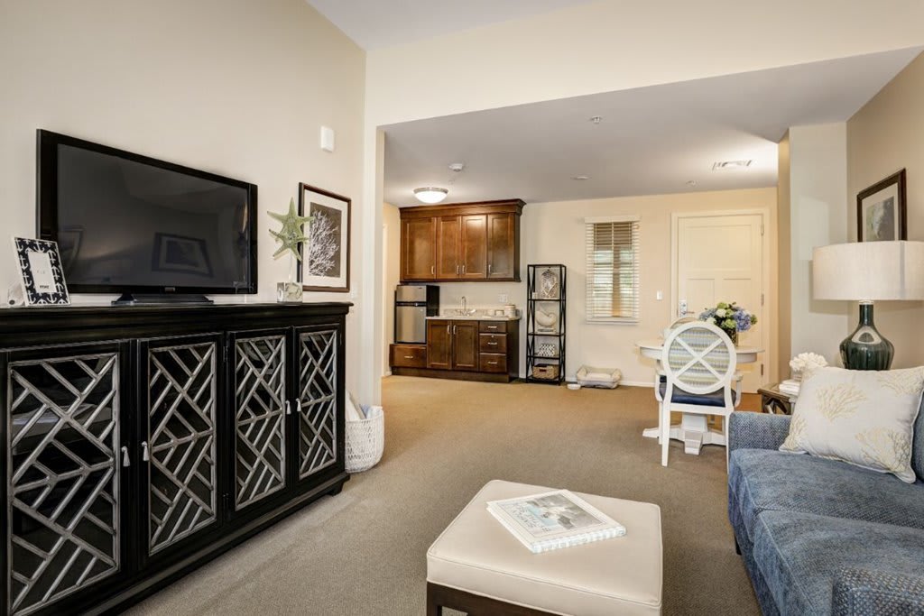 A modern living room with a television, cabinet, and cozy seating area.