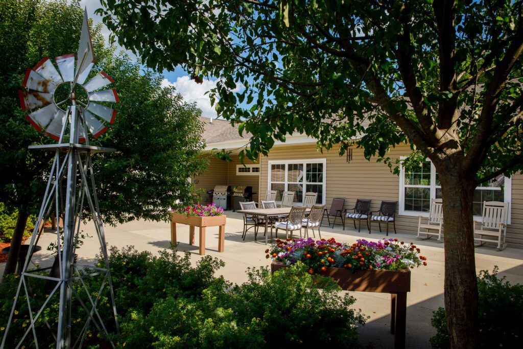 A sunny outdoor patio with garden furniture and colorful flowers.