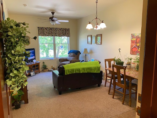 A cozy and inviting living space featuring a comfortable couch, a dining area, and plenty of natural light.