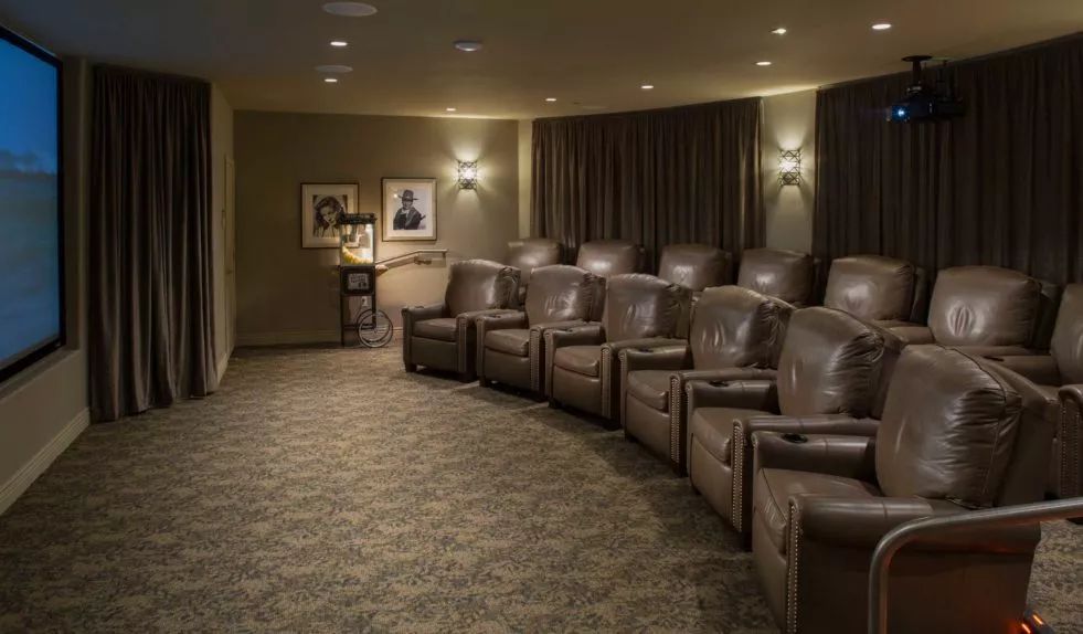 A luxurious home theater with comfortable leather seating arranged in rows.