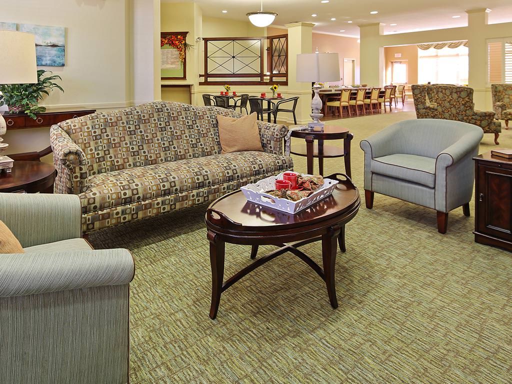 A cozy living room with a sofa, chairs, and a coffee table in a warmly decorated setting.