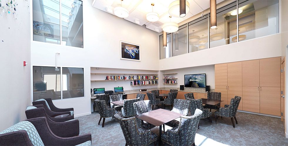 A spacious and modern lounge area with comfortable seating and bookshelves.
