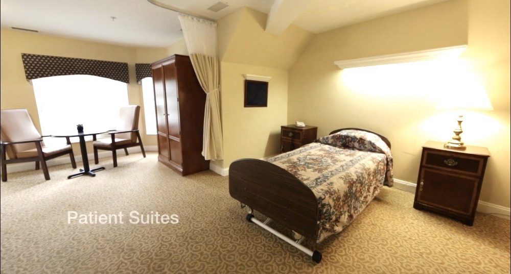 A cozy room with a hospital bed, wardrobe, and natural light from the window.