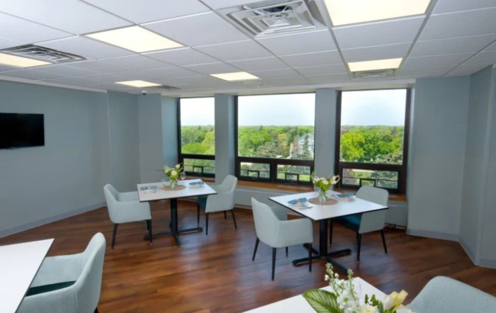 Modern dining area with large windows and contemporary furnishings.