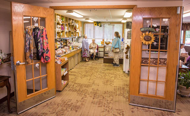 A cozy gift shop with various items on display and people browsing.