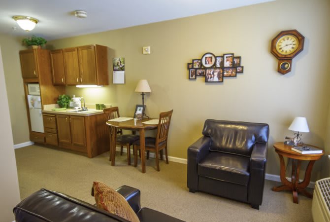 A cozy living room with a small dining area and kitchenette.