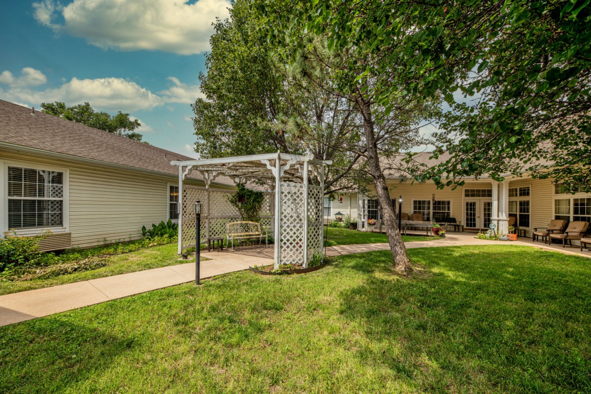 A serene backyard with a pergola and well-maintained lawn.